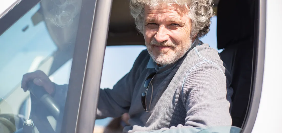 A driver in his sixties at the wheel of his car, in daylight